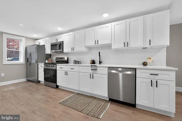 a kitchen with white cabinets and white appliances