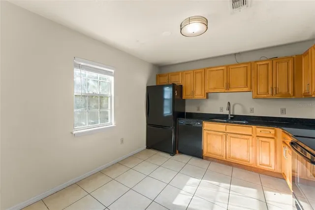 a kitchen with granite countertop a refrigerator and a sink