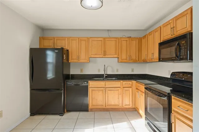 a kitchen with stainless steel appliances granite countertop a refrigerator a stove a sink and a microwave