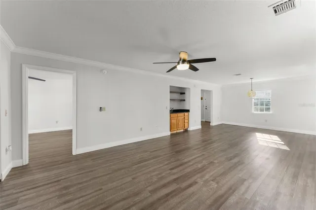 a view of empty room with wooden floor and ceiling fan