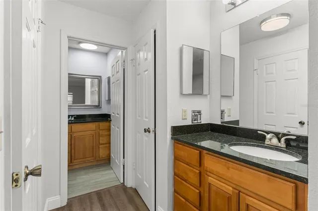 a bathroom with a granite countertop sink and a mirror