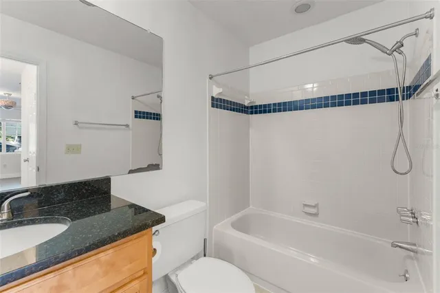 a bathroom with a granite countertop sink and a bathtub