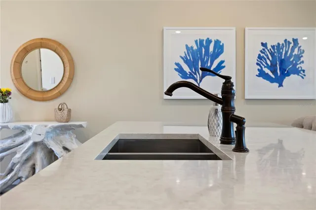 a kitchen with kitchen island granite countertop a dining table chairs refrigerator and cabinets