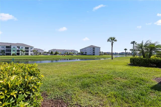 an aerial view of residential houses with outdoor space and a lake view