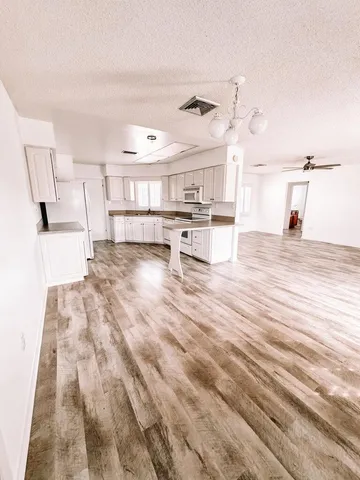 an empty room with a ceiling fan and a window