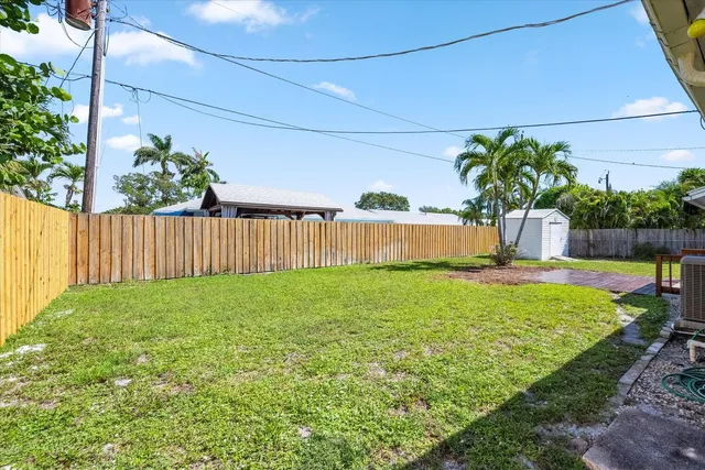 a front view of house with yard and trees in the background