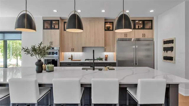 a kitchen with stainless steel appliances kitchen island a refrigerator sink and cabinets