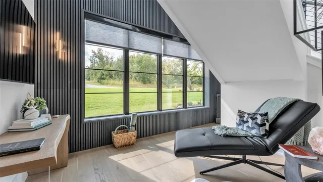 a living room with furniture a rug kitchen view and a window