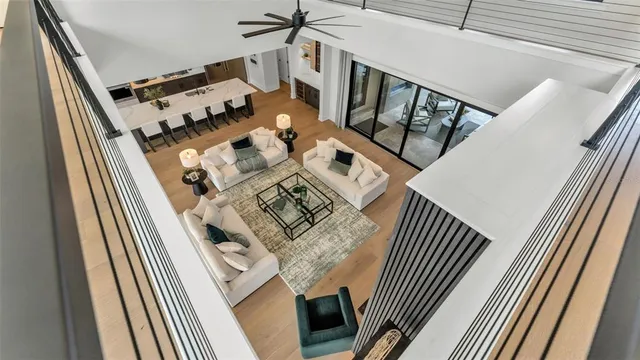 a view of a hallway with wooden floor and a living room