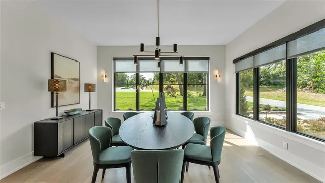 a dining room with furniture a chandelier and wooden floor