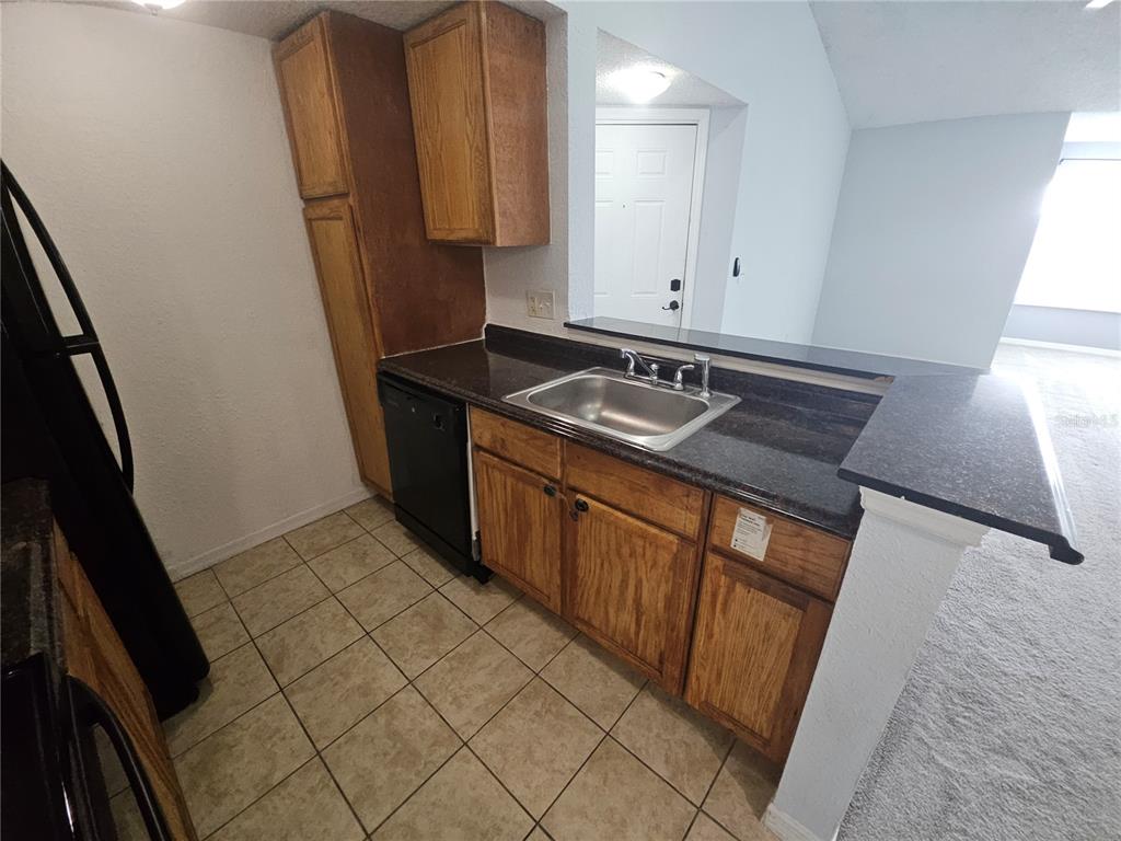 5160 Conroy Road, Unit 1437 Orlando, FL 32811 - Photo 13 of 36 a kitchen with stainless steel appliances granite countertop a stove a sink and a refrigerator