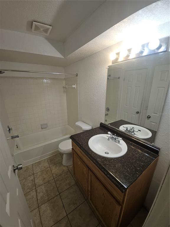 5160 Conroy Road, Unit 1437 Orlando, FL 32811 - Photo 22 of 36 a bathroom with a granite countertop sink a toilet a mirror and bathtub
