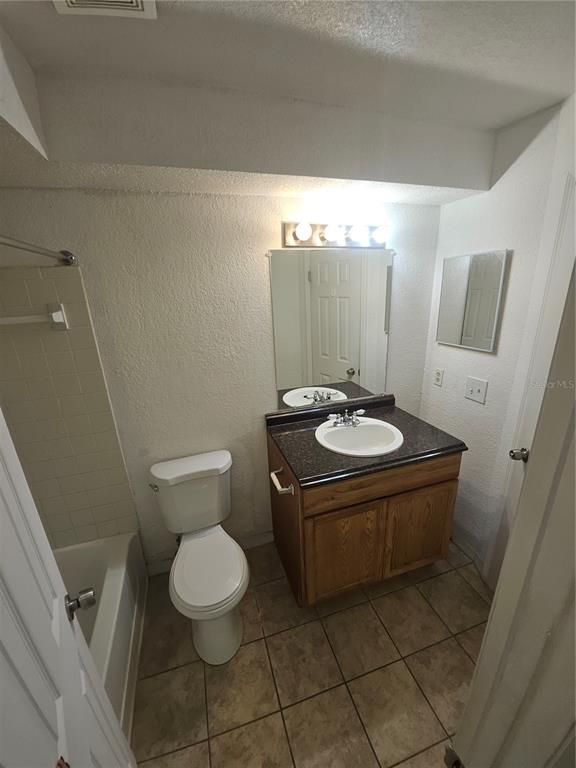 5160 Conroy Road, Unit 1437 Orlando, FL 32811 - Photo 25 of 36 a bathroom with a toilet sink and mirror