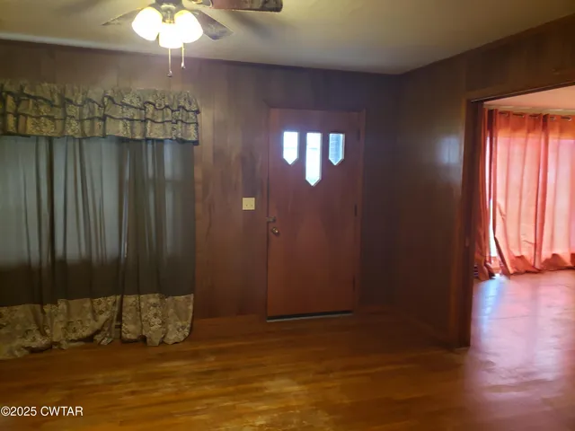a view of a room has wooden floor and brick walls