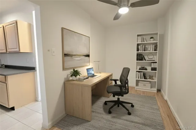 a view of a workspace with furniture and a window