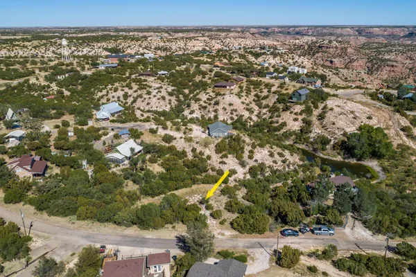 an aerial view of house with yard and mountain view in back