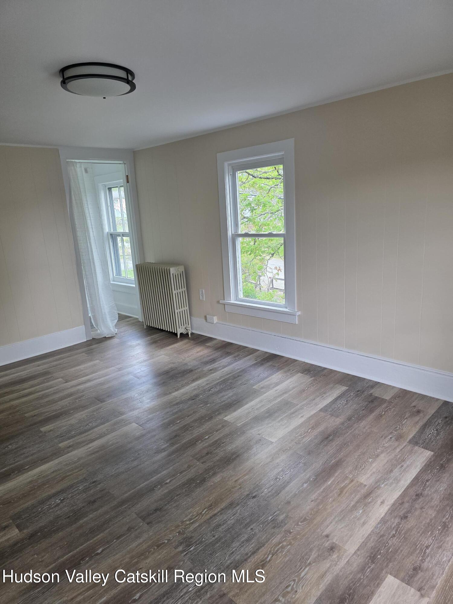 22 Maple Street Catskill, NY 12414 - Photo 11 of 16 an empty room with wooden floor and windows