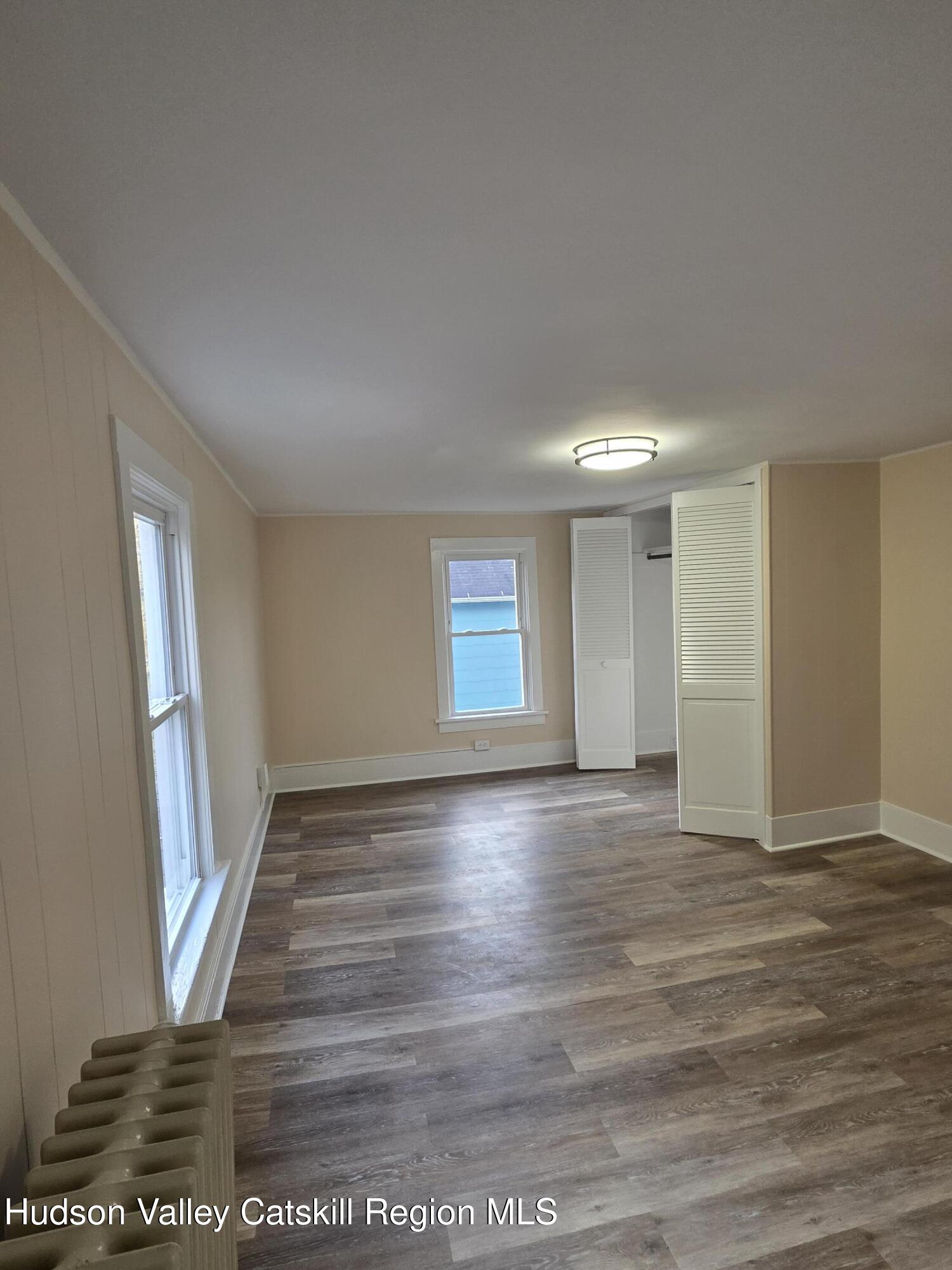 22 Maple Street Catskill, NY 12414 - Photo 12 of 16 a view of an empty room with wooden floor and a window