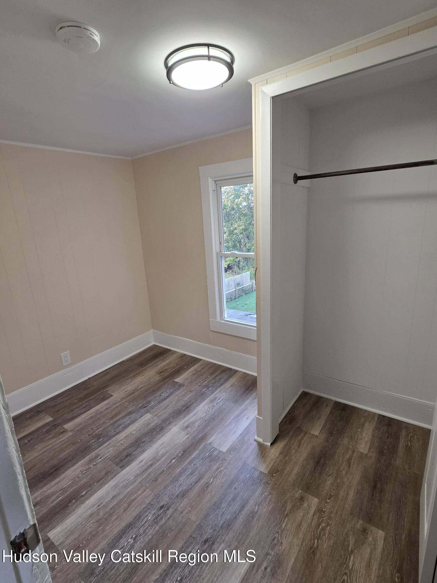 22 Maple Street Catskill, NY 12414 - Photo 14 of 16 an empty room with wooden floor and window
