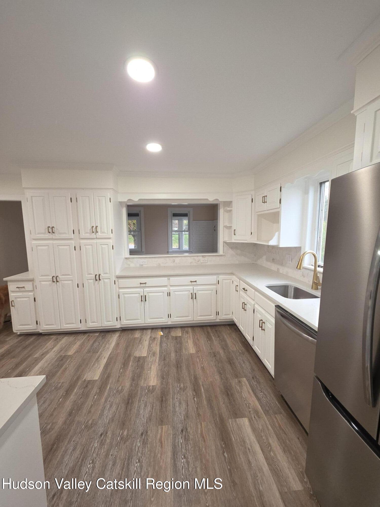 22 Maple Street Catskill, NY 12414 - Photo 6 of 16 a large kitchen with cabinets wooden floor and stainless steel appliances