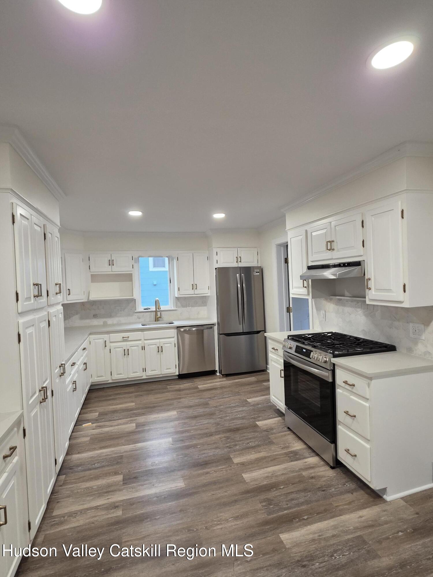 22 Maple Street Catskill, NY 12414 - Photo 7 of 16 a large kitchen with stainless steel appliances granite countertop a stove a sink and white cabinets