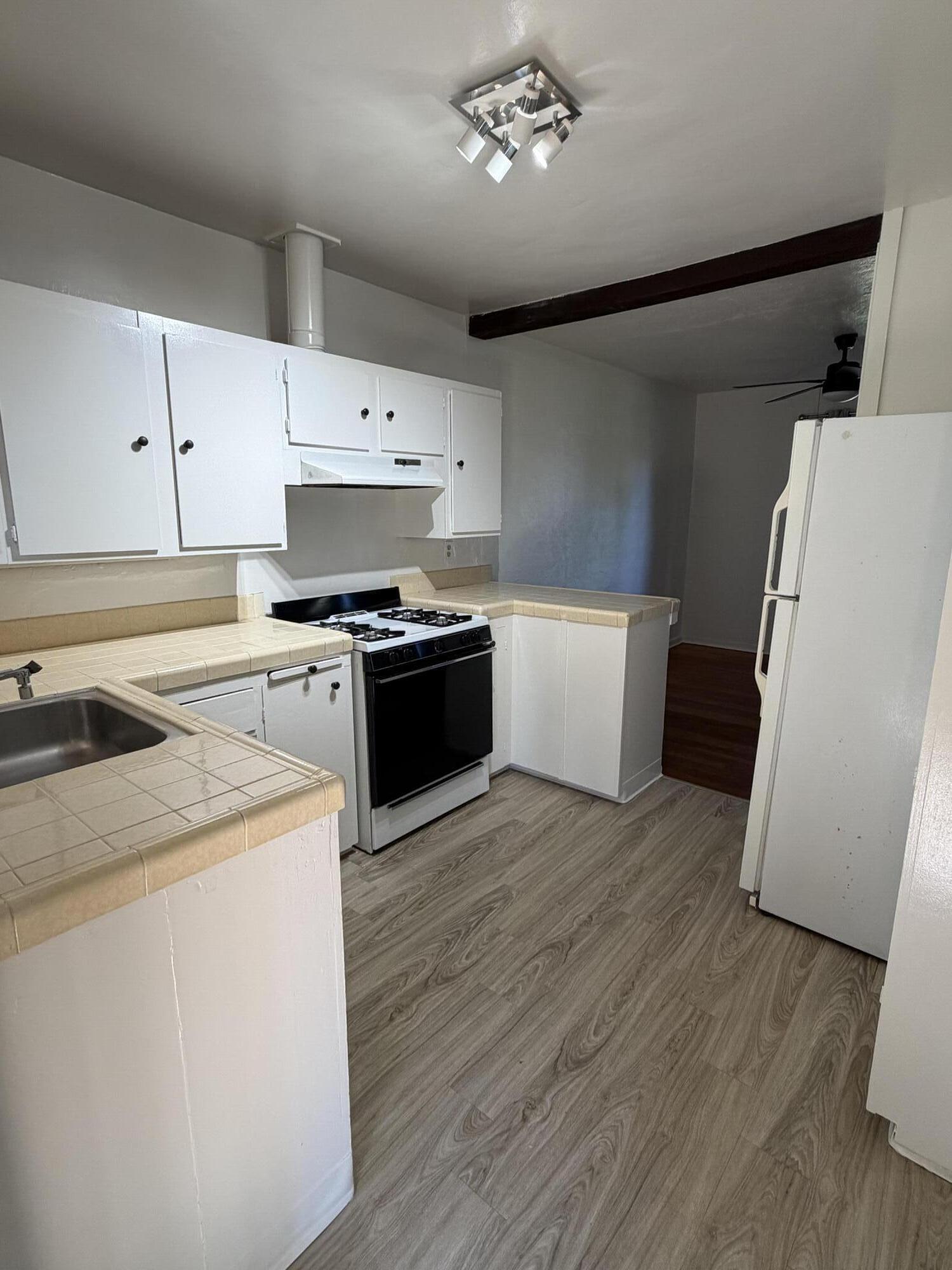 316 Oceano Avenue, Unit B Santa Barbara, CA 93109 - Photo 3 of 17 a kitchen with a stove a refrigerator and a microwave