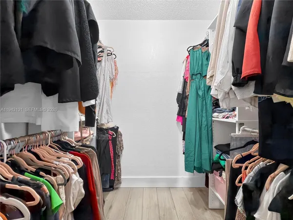 a view of walk in closet with clothes and shoes
