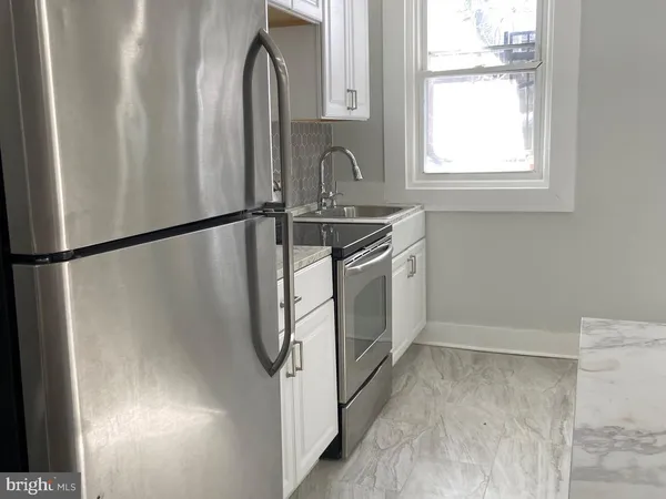 a kitchen with a refrigerator a sink and a window