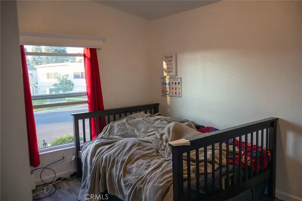 a bed sitting in a bedroom next to a window