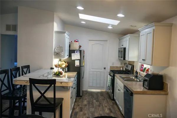 a kitchen that has a table chairs and a refrigerator