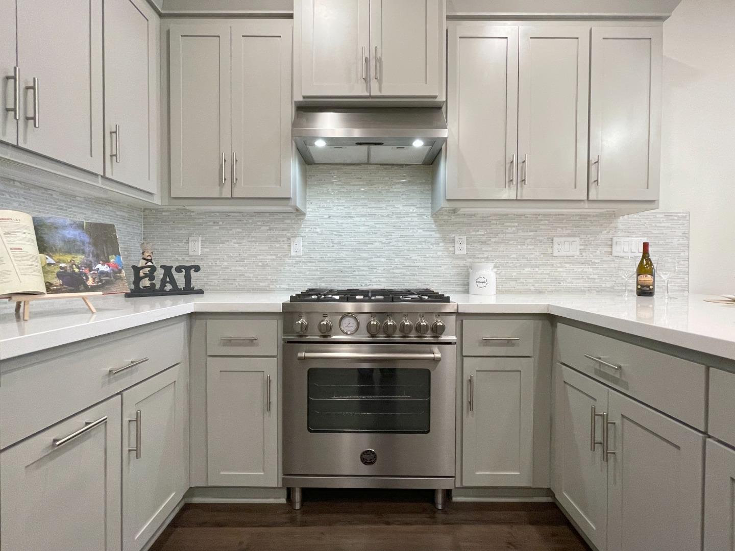 716 Amalfi Loop Milpitas, CA 95035 - Photo 5 of 28 a kitchen with white cabinets and white appliances