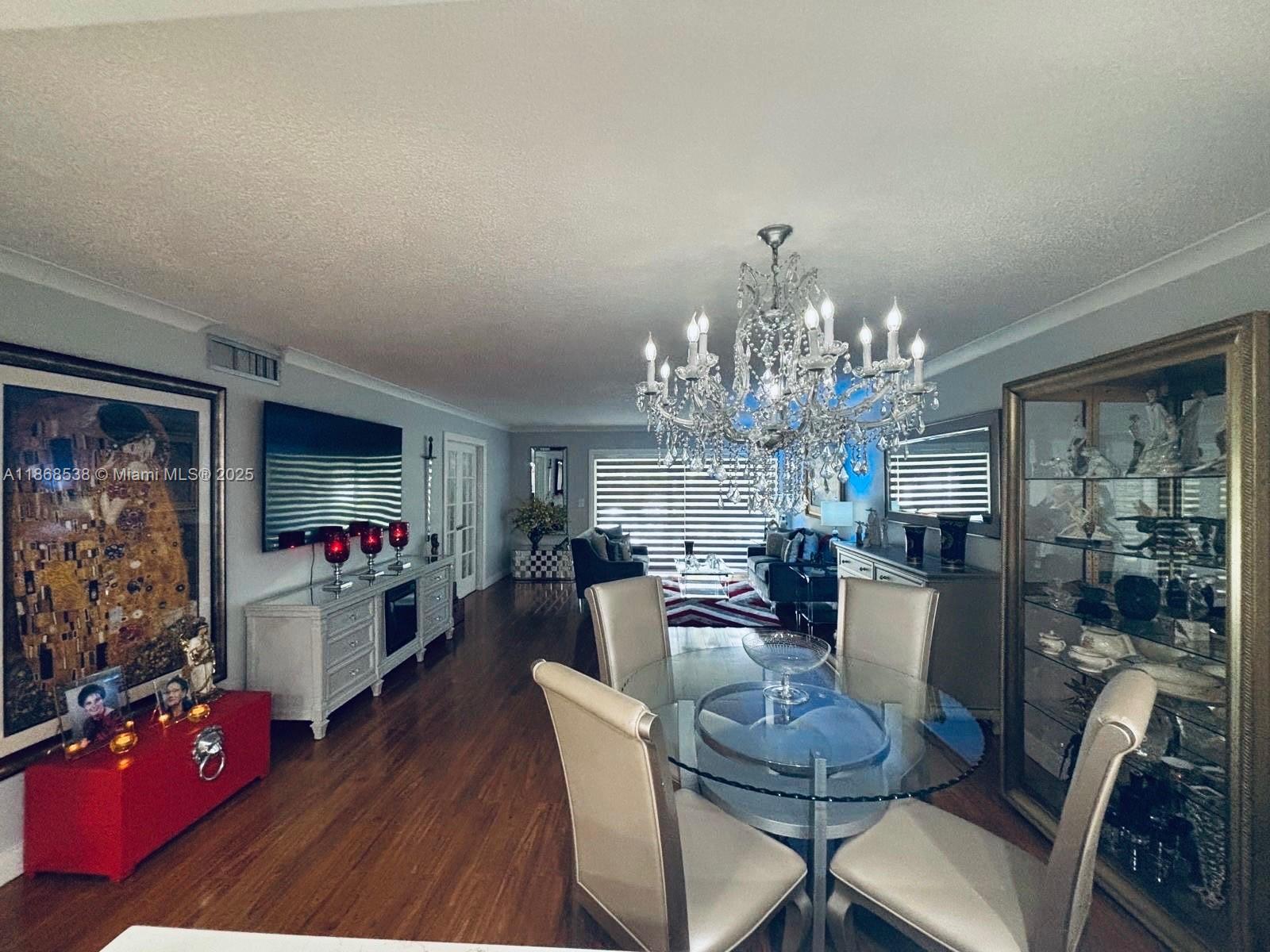 3501 Inverrary Drive, Unit 201 Lauderhill, FL 33319 - Photo 9 of 35 a view of a dining room with furniture a chandelier and wooden floor