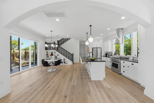 a large kitchen with kitchen island a large counter space a sink stainless steel appliances and cabinets