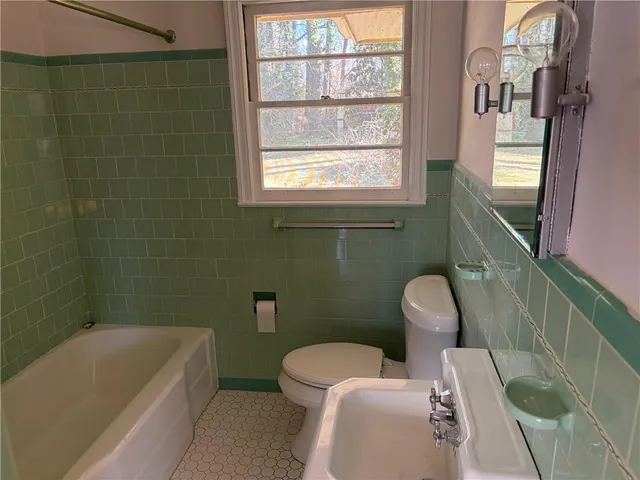 a bathroom with a sink a toilet a bathtub and window