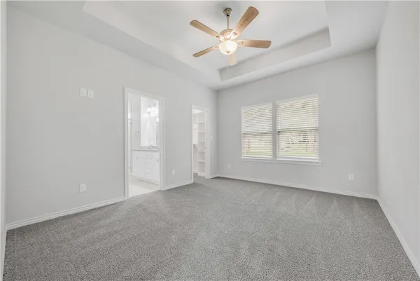 an empty room with a ceiling fan and a window
