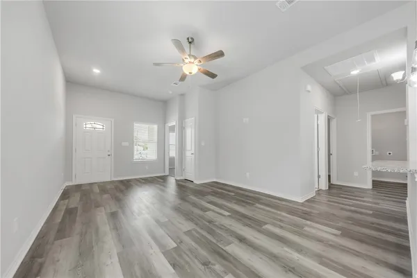 an empty room with wooden floor and windows