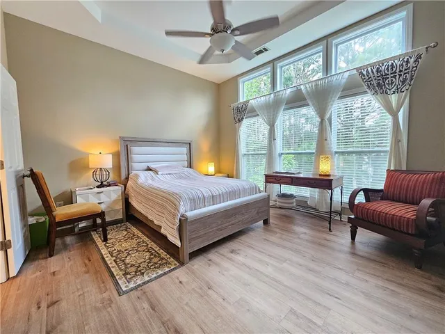 a bedroom with a bed and wooden floor