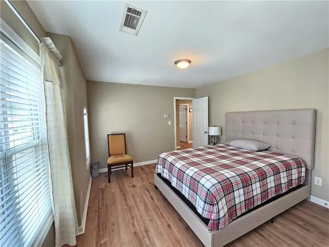 a bedroom with a bed and wooden floor