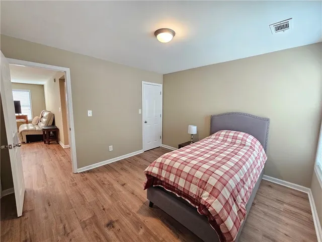 a bedroom with a bed and wooden floor
