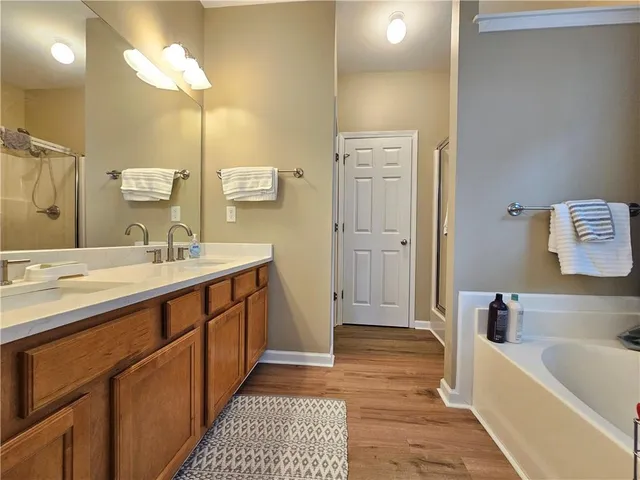 a bathroom with a tub sink and mirror