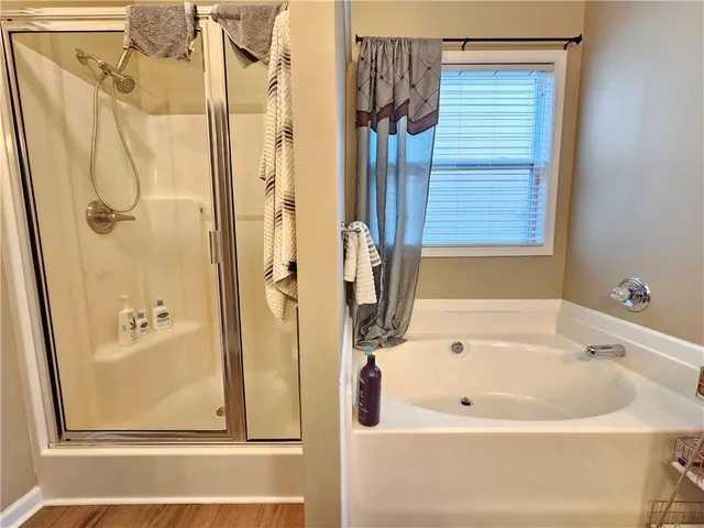a white bath tub sitting next to a shower