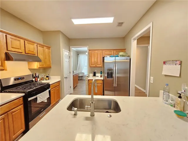 a kitchen with kitchen island granite countertop a stove and a refrigerator