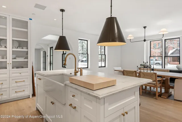 a kitchen with a sink a stove a dining table and chairs