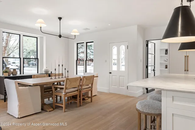 a view of a a dining room with furniture window and wooden floor