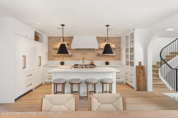 a kitchen with stainless steel appliances kitchen island granite countertop a sink and a refrigerator