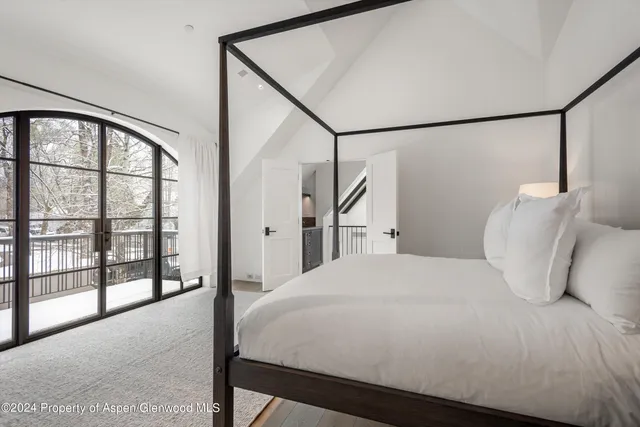 a bedroom with a large bed and a large window