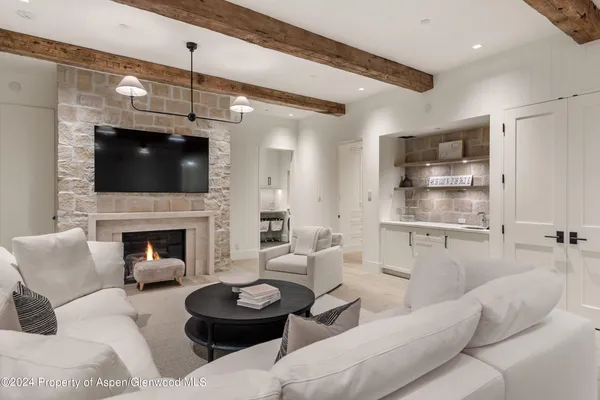 a living room with furniture a flat screen tv and a fireplace