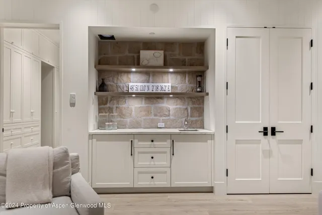 a living room with white cabinets and a wooden floor