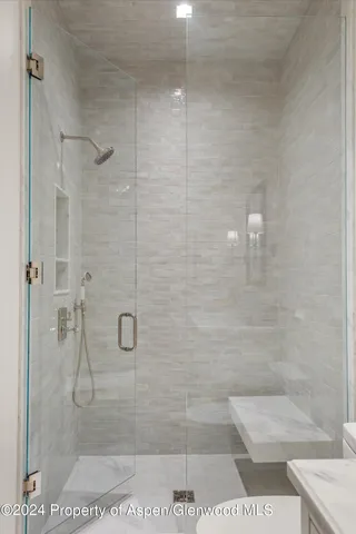 a bathroom with a shower sink and mirror