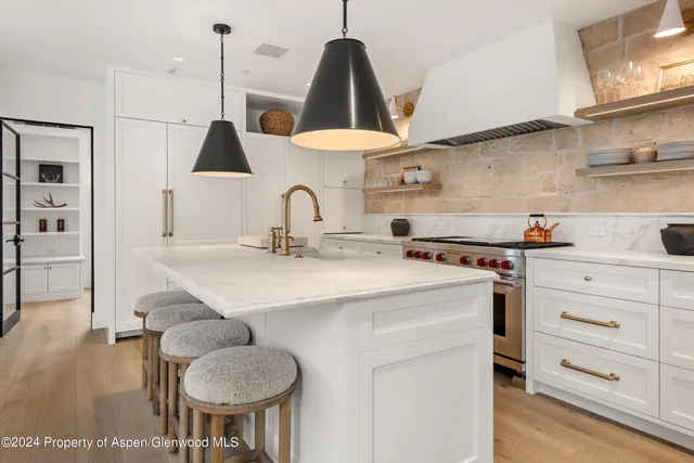 a kitchen with a stove a sink and a chandelier